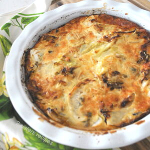 A white baking pie dish with a cabbage au gratin fully baked.