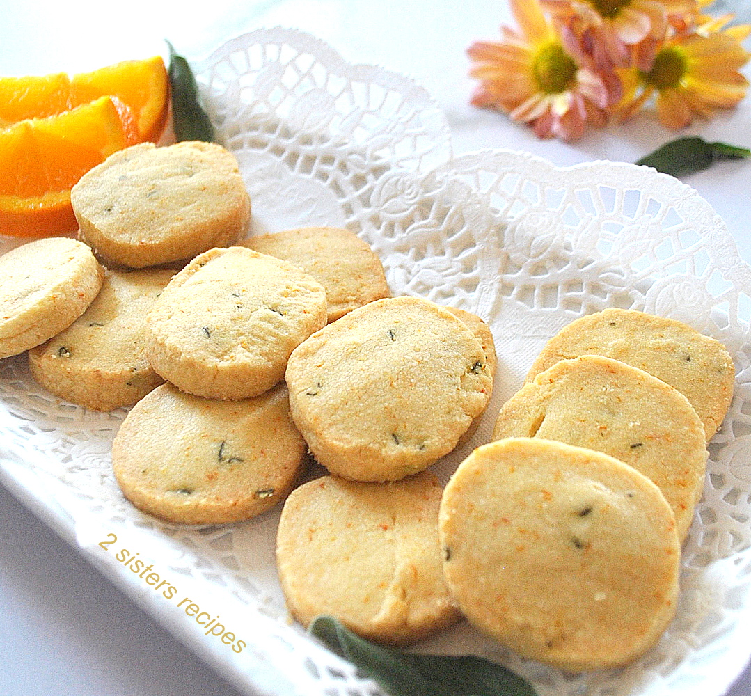 A white platter filled with baked orange and sage shortbread cookies.
