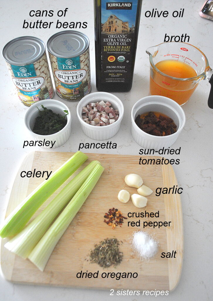 2 can of butter beans, 3 stalks of celery, a cup of broth, garlic cloves, seasonings, plus white bowls with other ingredients.