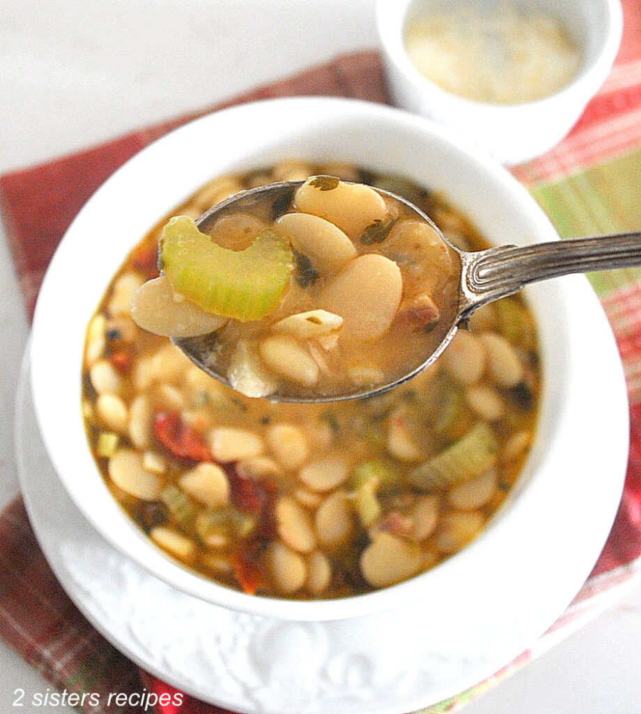 A spoonful of butter beans soup with veggies.