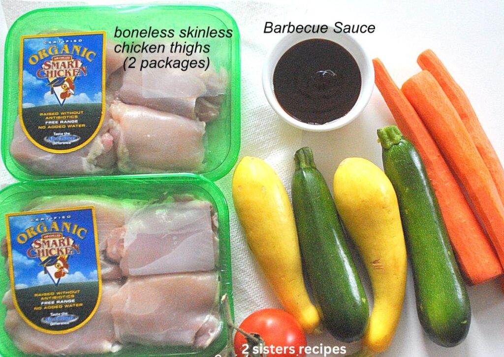 two packages of boneless chicken thighs, 3 carrots, 2 zucchini, 2 yellow squash and a bowl of BBQ sauce.