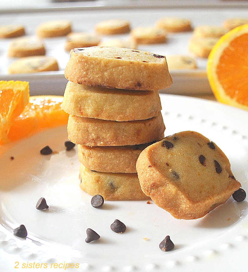 A pile of orange shortbreads with mini chocolate chips on the white plate.