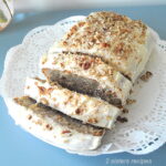 A loaf of hummingbird quick bread sliced on a white doily.