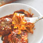 A forkful of tagliatella pasta with tomato sauce.