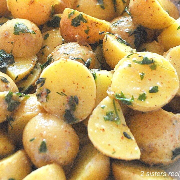 Small potatoes sliced in half, with fresh herbs.