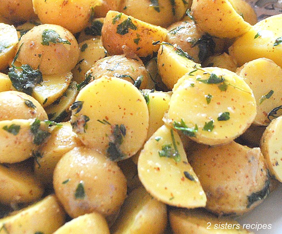 Small potatoes sliced in half, with fresh herbs.