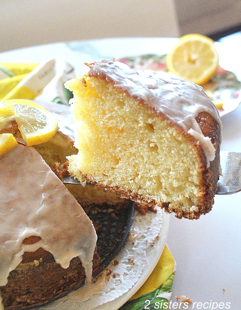 A slice of lemon cake is pulled from the cake,