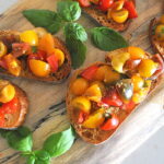 A charcuterie board filled with bruschetta al pomodoro.