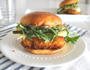 A fish sandwich set on a white plate.