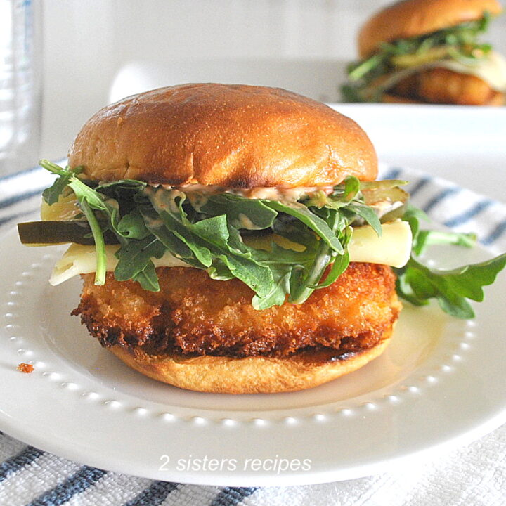 A fish sandwich set on a white plate.