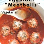 A white Dutch oven filled with eggplant meatballs and tomato sauce with a wooden spoon.