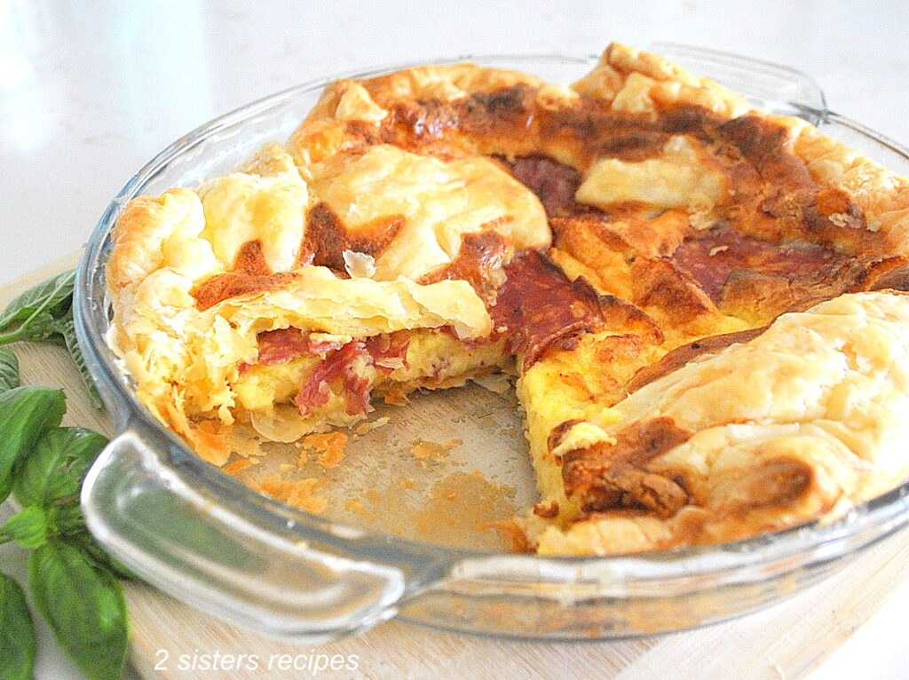 A slice of quiche taken from a pie dish.