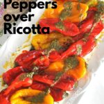 A white rectangular platter filled with charred peppers over a bed of ricotta cheese.