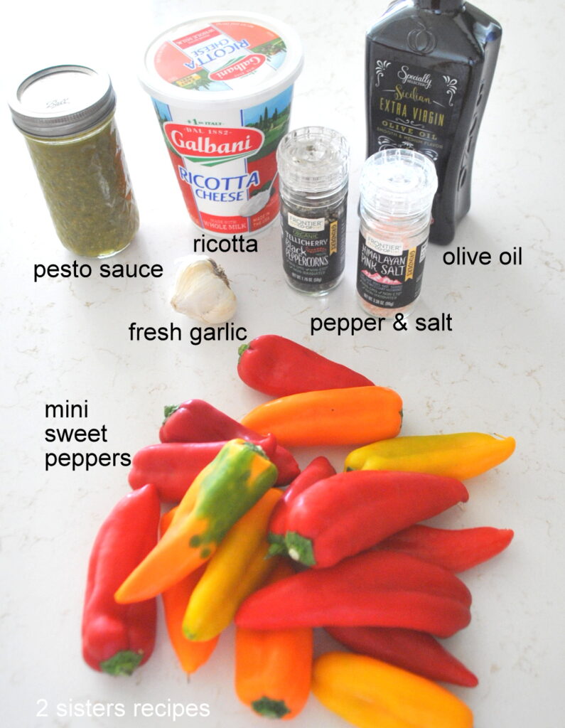 Colorful small peppers plus a container of ricotta and salt and pepper on the counter.