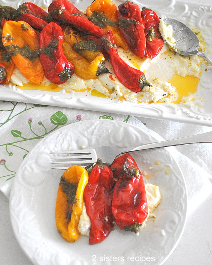 a white dish with some ricotta cheese and charred peppers over it, served with a fork.