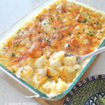 A glass Pyrex glass baking filled with baked potato and cream cheese sauce.