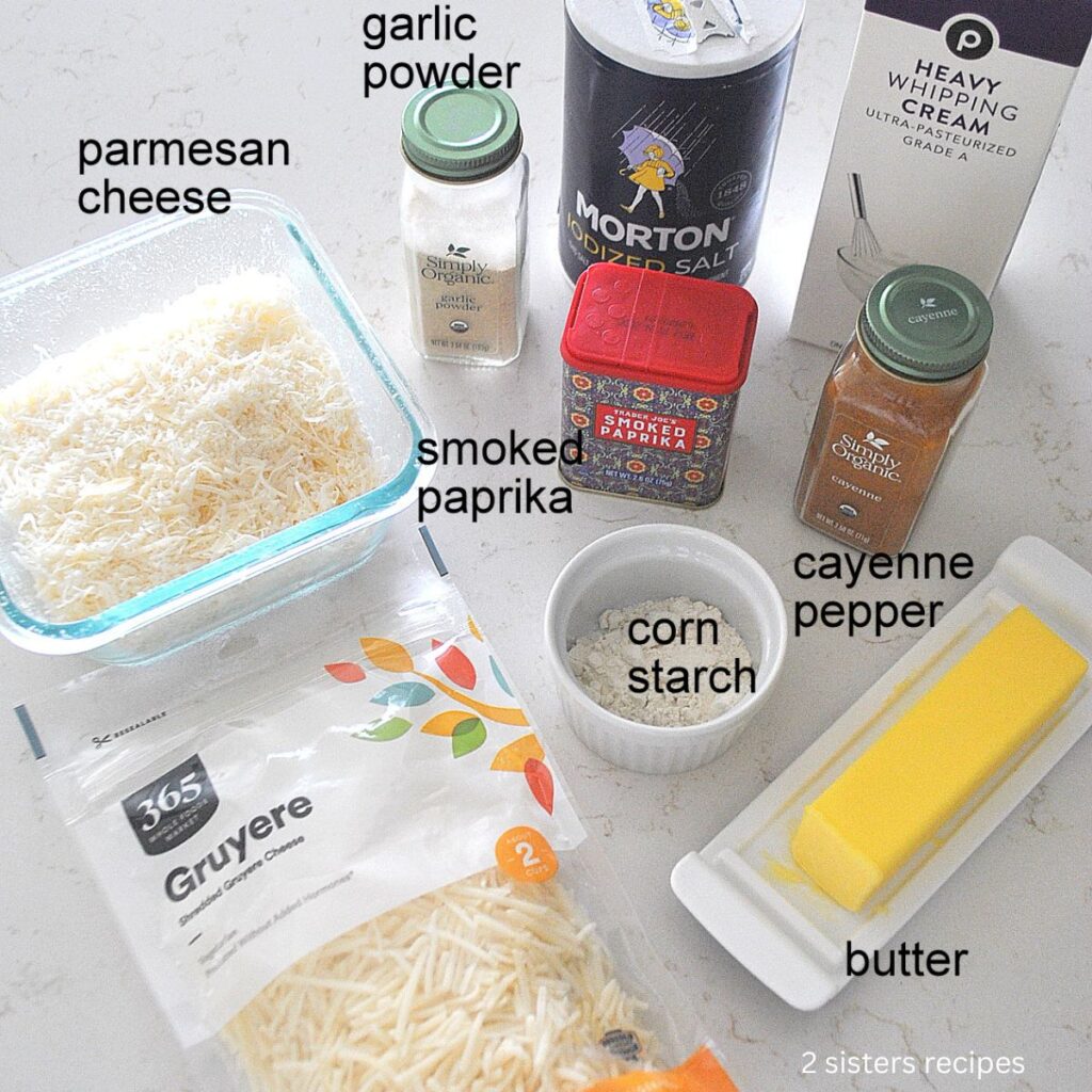 A stick of Butter, a package of shredded cheese, salt, heavy cream are set on the counter.