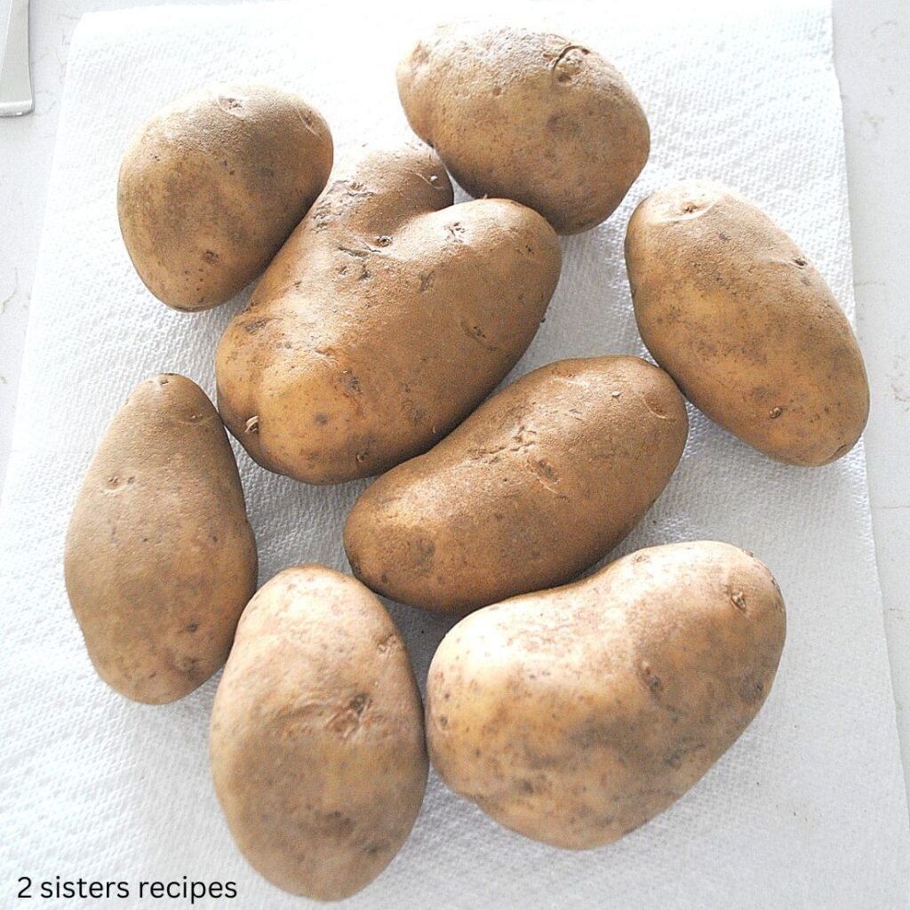 Eight Russet potatoes are laid on the counter.