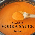 A black skillet on stove top with orange-color Vodka sauce and a wooden spoon.