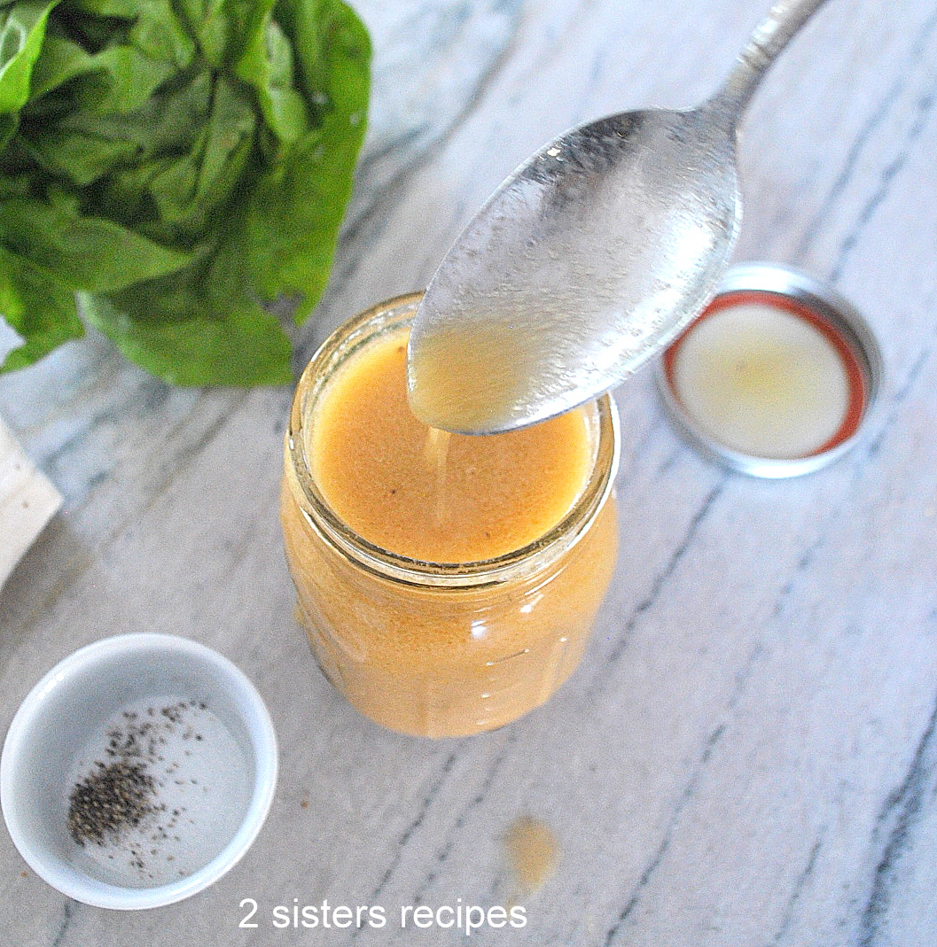 Simple Vinaigrette Salad Dressing A mason jar filled with a salad dressing and a spoonful .