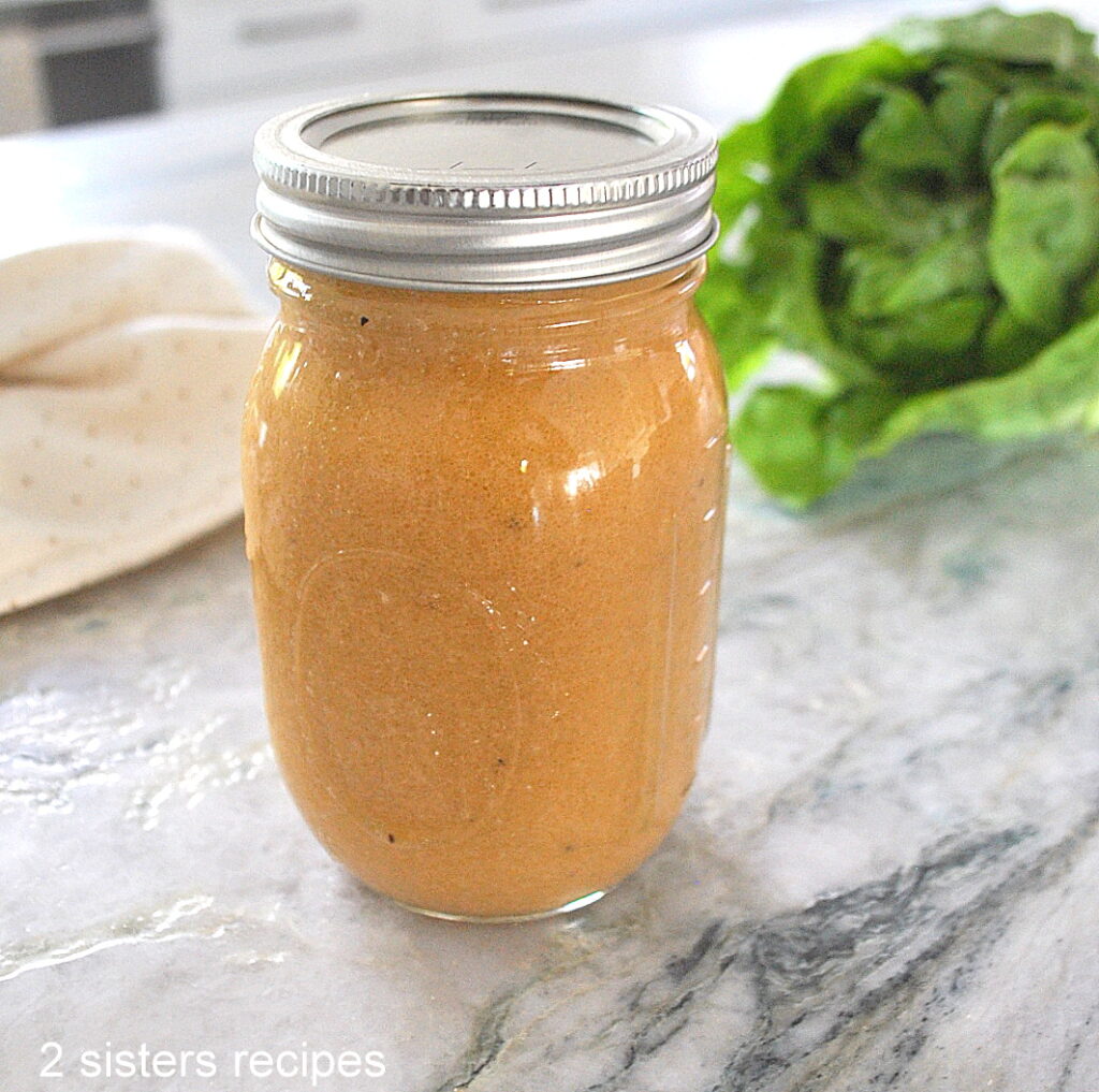 A mason jar filled with a salad dressing on the counter.