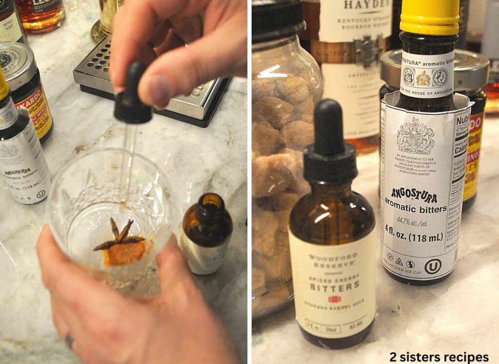 A cocktail glass with a dropper and 2 bottles of bitters set on the counter.