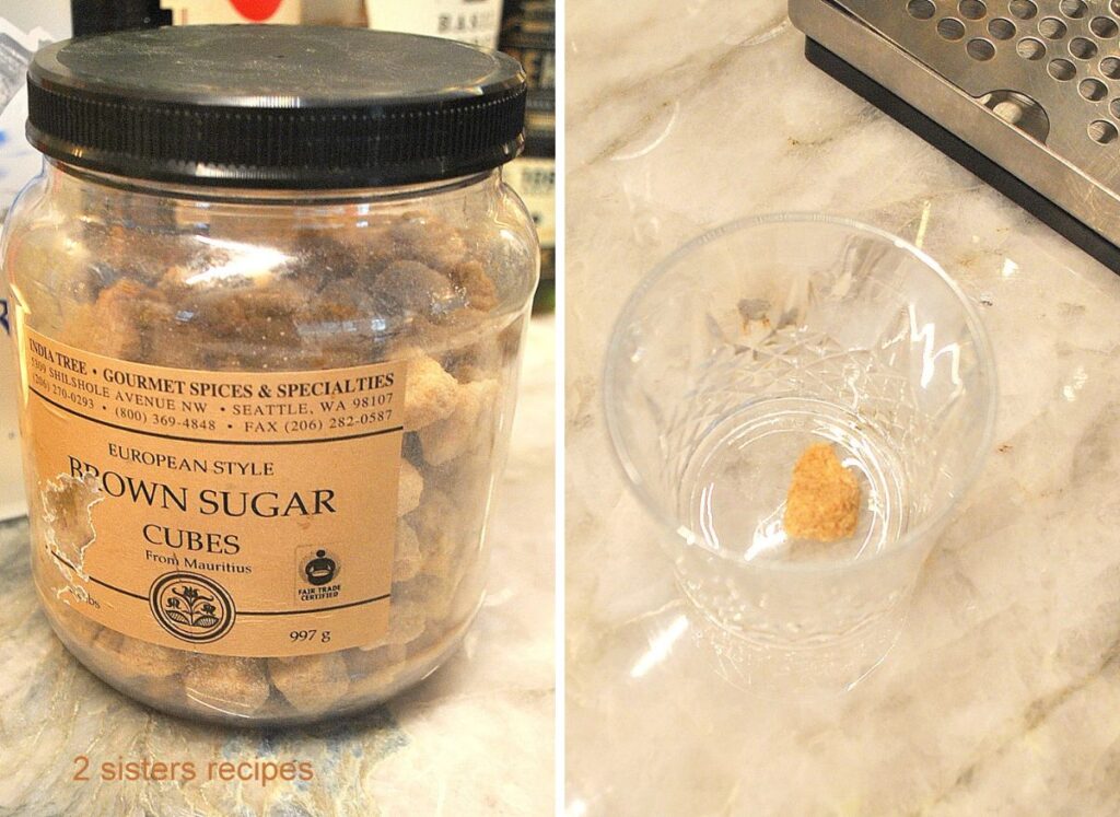 A bottle of brown sugar cubes and a whiskey glass with one sugar cube in the glass.