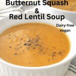 A white bowl filled with pureed soup of butternut and red lentil soup.