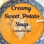 A blue bowl filled with a creamy sweet potato soup and grated cheese on top.