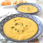 A blue bowl filled with a creamy potato soup.