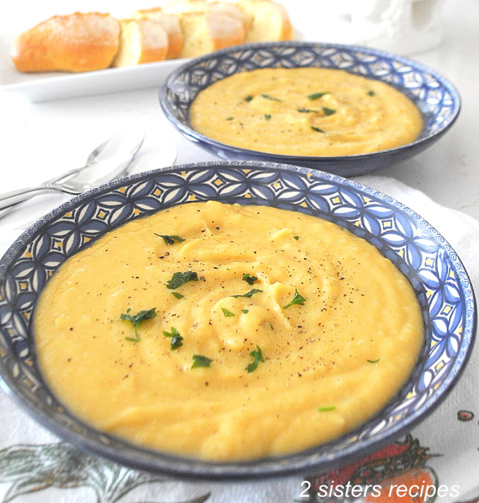 A blue bowl filled with a creamy potato soup.