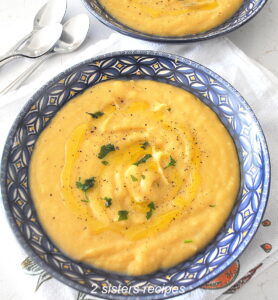 A blue bowl filled with creamy potato soup.