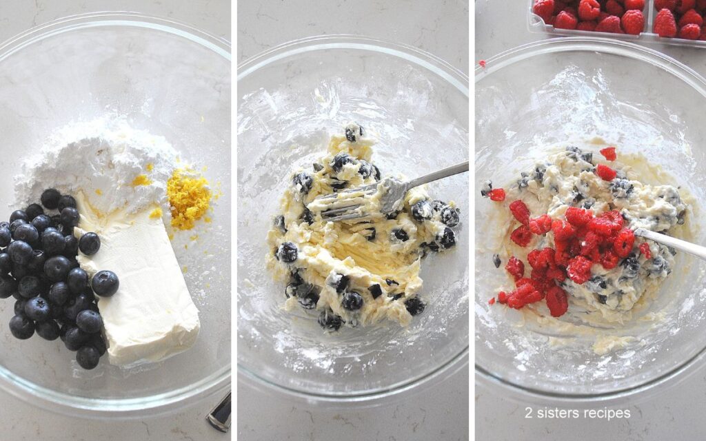 A glass bowl with a block of cream cheese, blueberries, lemon zest, and raspberies.