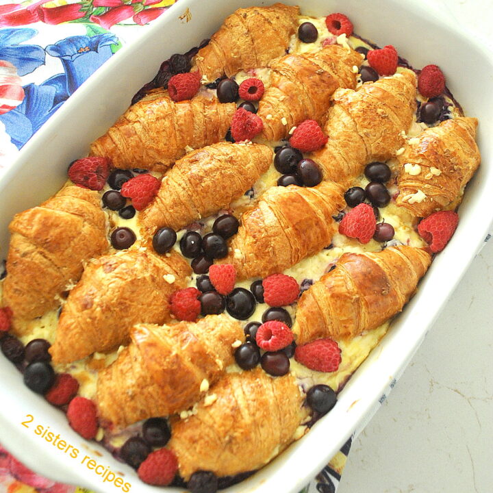 A casserole with baked croissants, custard and berries.