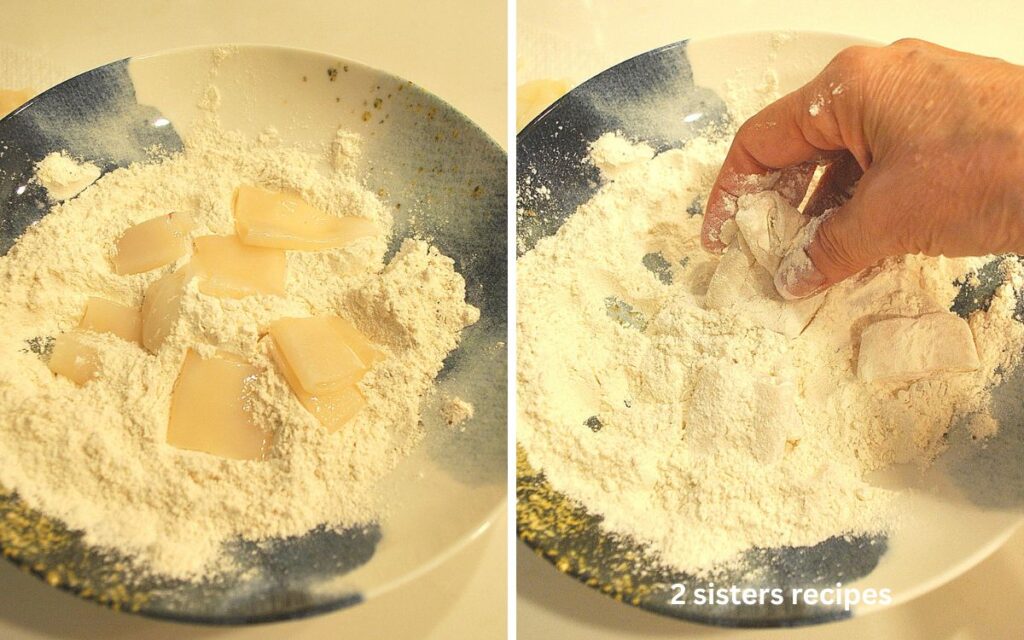 A bowl filled with flour and thawed calamari pieces.