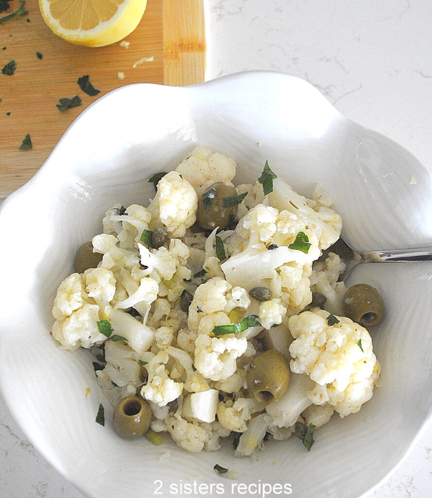 A white bowl filled with cauliflower salad.