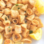 Crispy fried calamari served with lemon wedges.