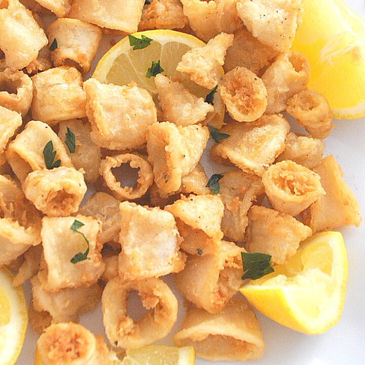 Crispy fried calamari served with lemon wedges.