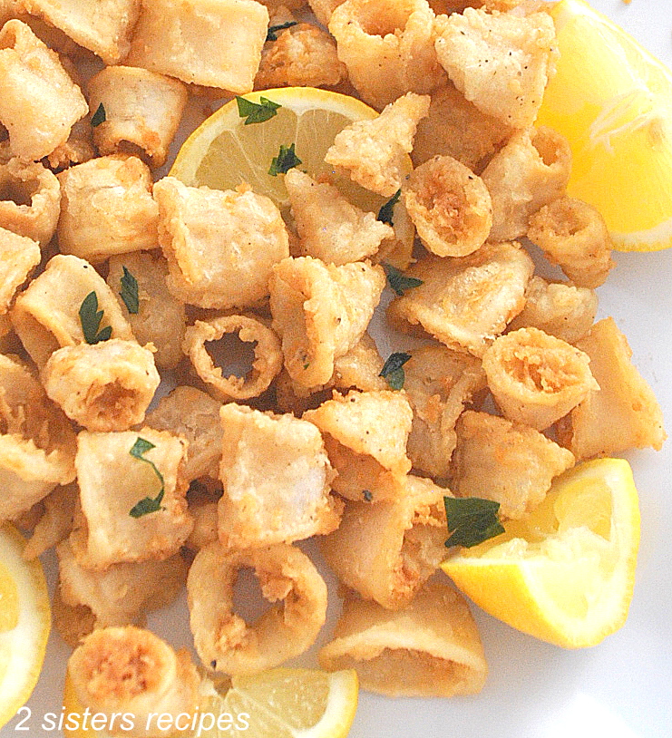 Crispy fried calamari served with lemon wedges.