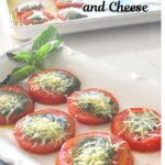 A white platter filled with baked sliced tomatoes topped with pesto and cheese.
