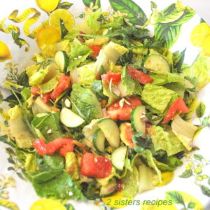 A bright yellow salad bowl filled with a fresh green salad with tomatoes, cucumbers and crisp lettuce.