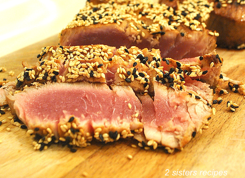 Sesame-Crusted Tuna Recipe A seared sesame-crusted tuna is sliced on a cutting board.