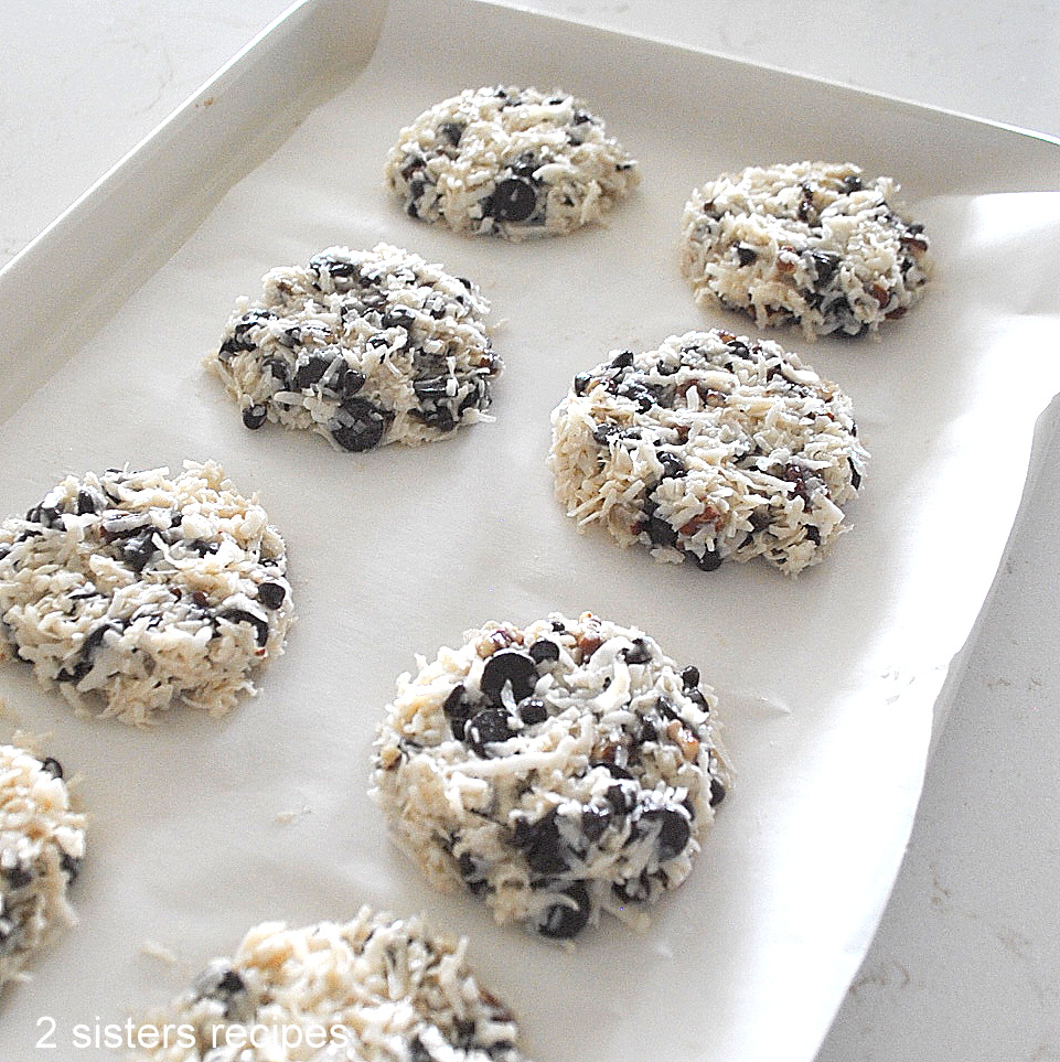 A baking sheet covered with parchment, and cookie dough ready for baking.