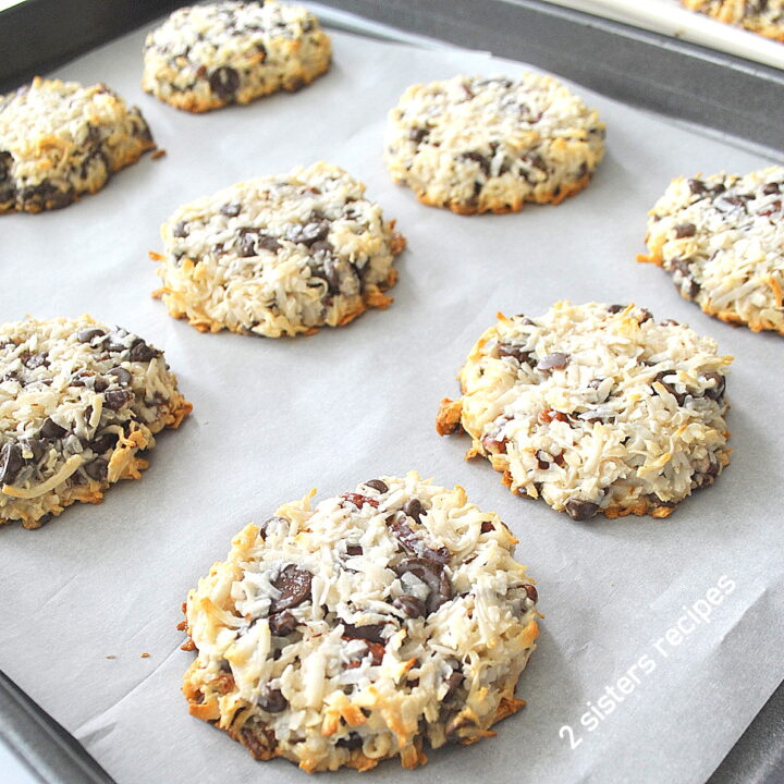 A baking sheet filled with baked coconut chocolate chip cookies.