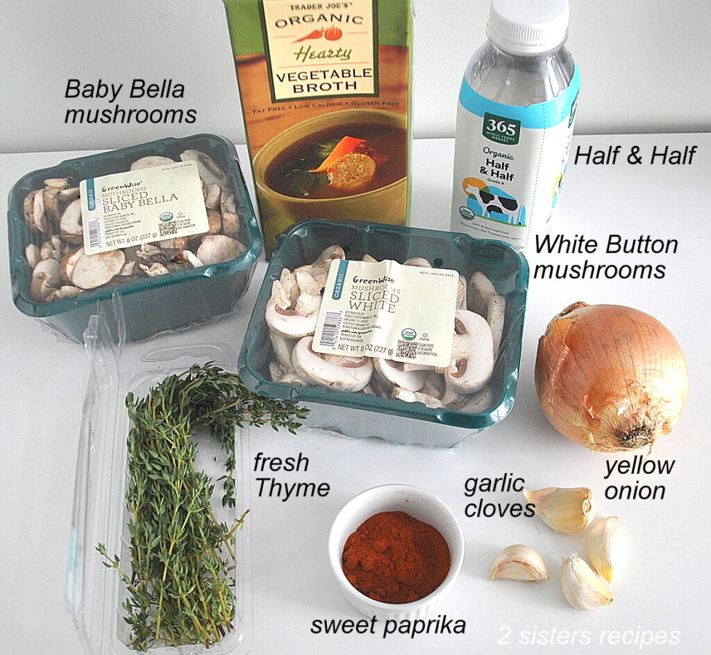 Packages of fresh sliced mushrooms, box of broth, onion and garlic cloves, fresh thyme and paprika are placed on the counter.