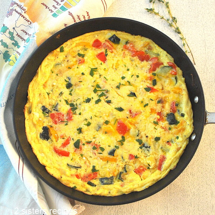 A black skillet with a cooked vegetable frittata.