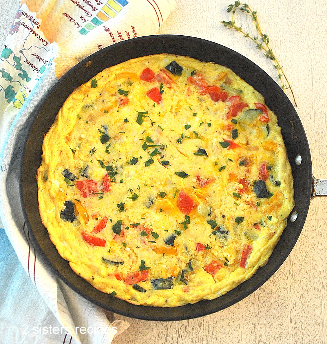 A black skillet with a cooked vegetable frittata.