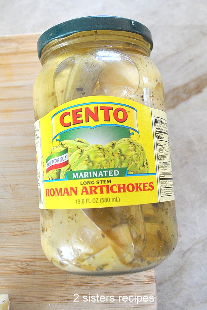 A jar of marinated artichokes with stems.