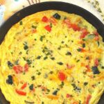 A vegetable frittata fully cooked inside a black skillet.