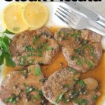A white dinner plate with 4 slices of thin steak in a sauce.